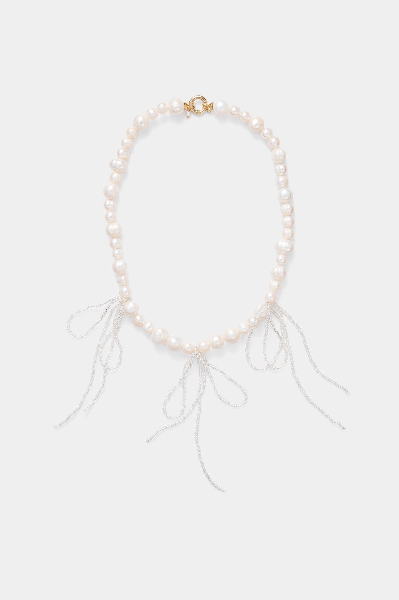Labro Grande Pearl Necklace met drie strikken op grijze achtergrond