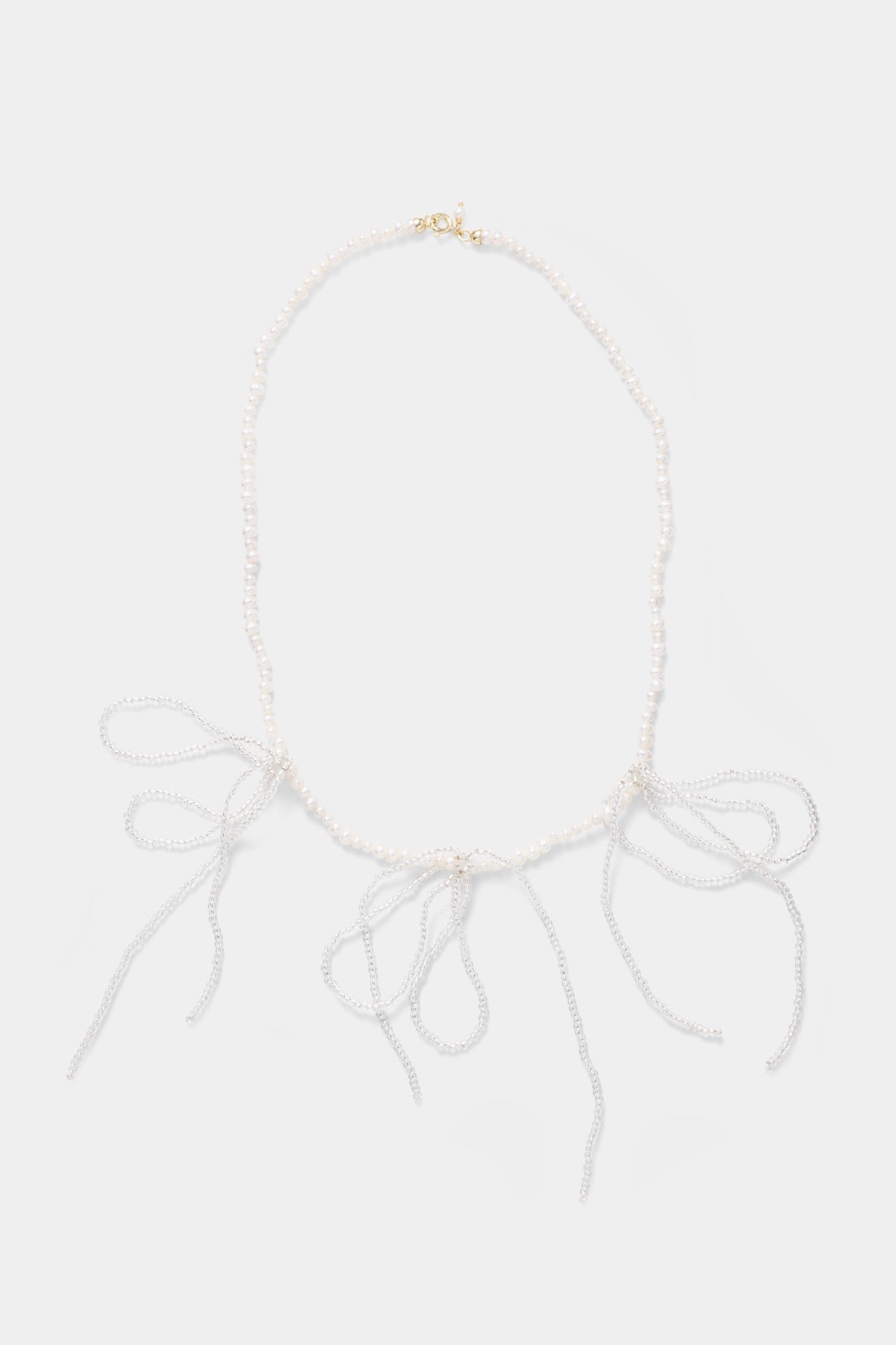 Labro Piccolo Pearl Necklace met drie strikken op grijze achtergrond