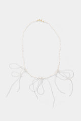 Labro Piccolo Pearl Necklace met drie strikken op grijze achtergrond